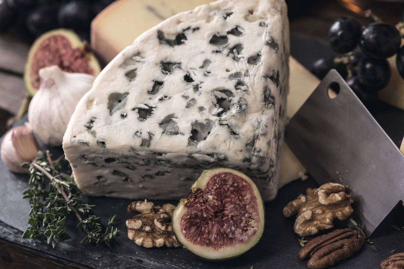 A cheeseboard with figs, walnuts and fresh herbs